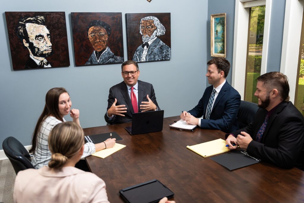 Team of attorneys at Jacob Stuart Law in Orlando, Florida collaborating during a firm meeting to discuss legal strategies